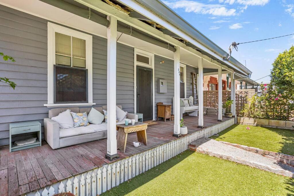 un porche de una casa con sofá y mesa en Saltbush Cottage in fabulous South Fremantle, en South Fremantle