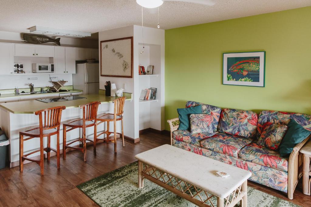 ein Wohnzimmer mit einem Sofa und einem Tisch sowie eine Küche in der Unterkunft Holualoa Garden 303 in Kailua-Kona