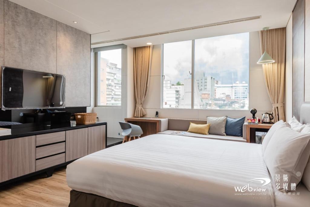 a hotel room with a large bed and a tv at Wow Happy- Taipei in Taipei