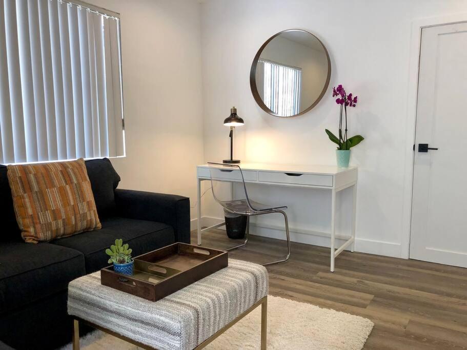 sala de estar con sofá negro y espejo en Silverlake and Echo Park - 6min to Downtown and Hollywood - en Los Ángeles