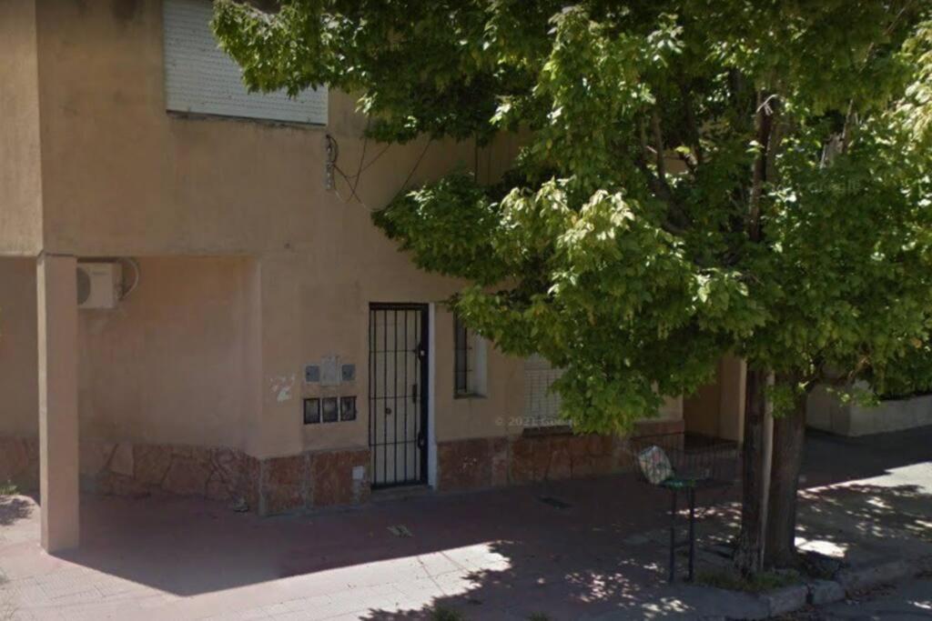 Comodo departamento en Cordoba في قرطبة: شجرة امام مبنى مع بوابة