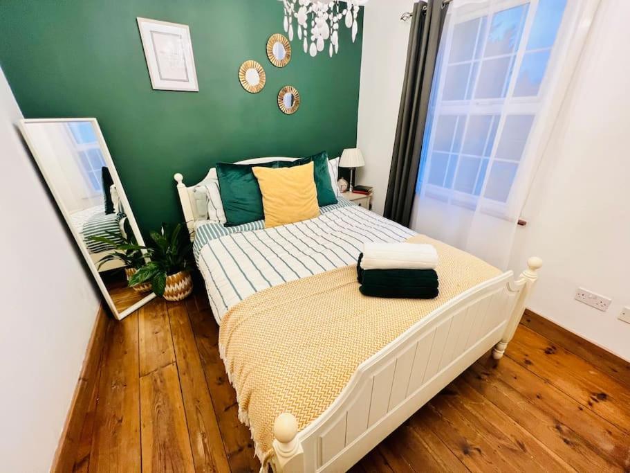 een slaapkamer met een bed met een groene muur bij Cosy Cottage in Central Reading Free Parking & Fast Wifi in Reading