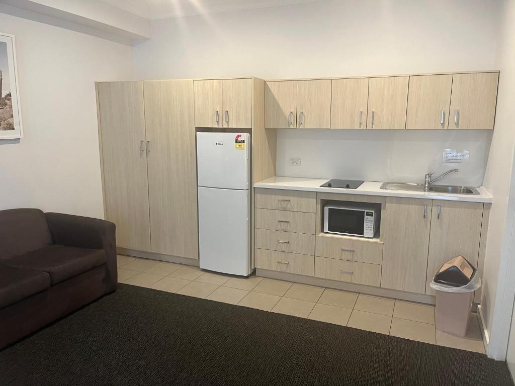 a kitchen with a white refrigerator and a sink at Nagambie Waterfront Motel in Nagambie