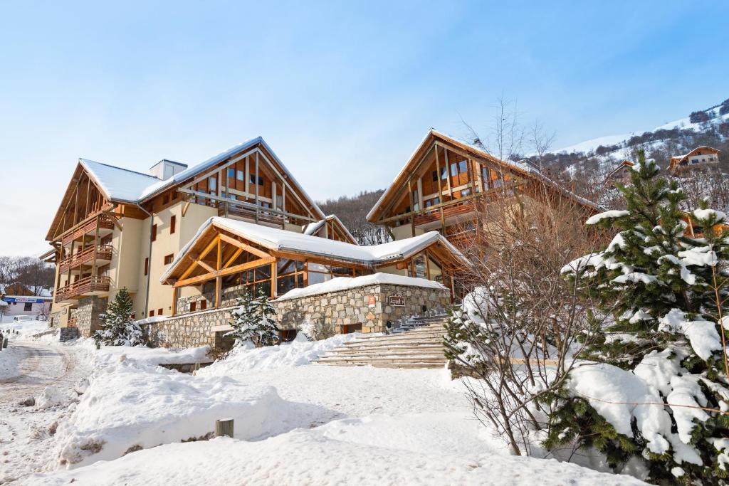 eine Lodge im Schnee mit schneebedecktem Gelände in der Unterkunft Lagrange Vacances Chalets du Galibier in Valloire
