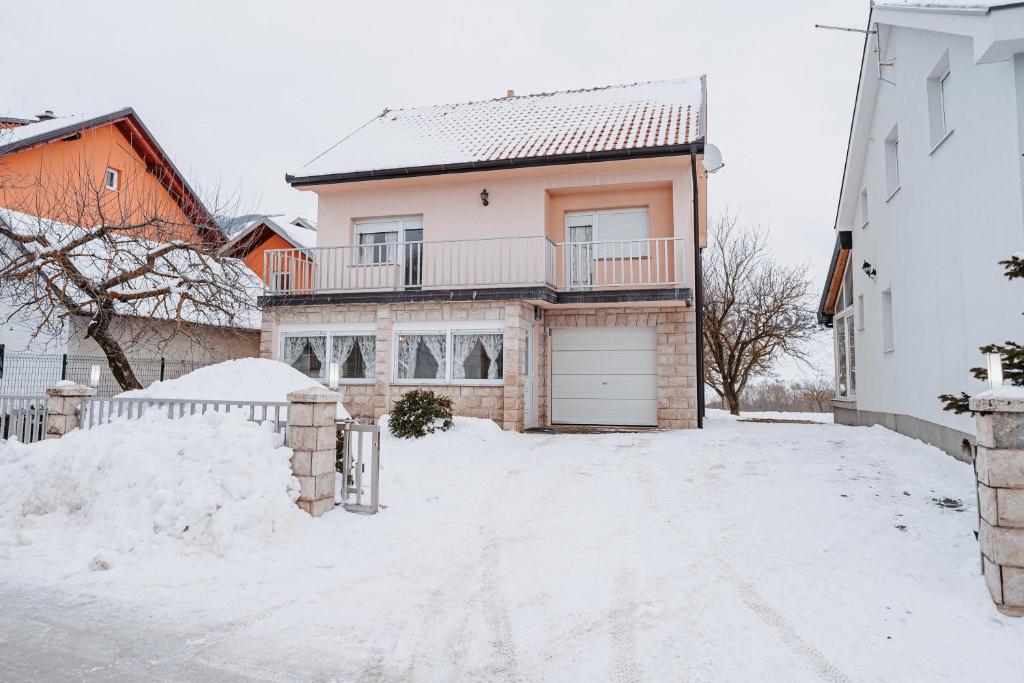 una casa bianca con un garage nella neve di CosyHouse-Kupres a Kupres