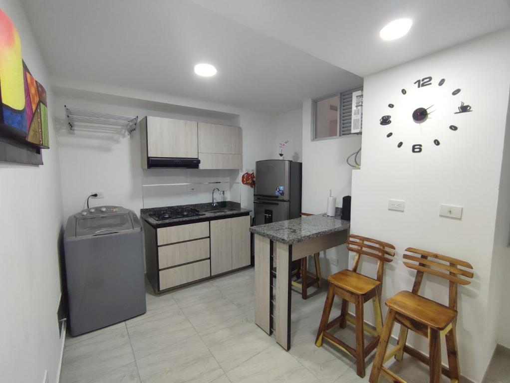 uma cozinha com mesa e cadeiras e um relógio na parede em Apartamento Almendros Home em Santa Rosa de Cabal