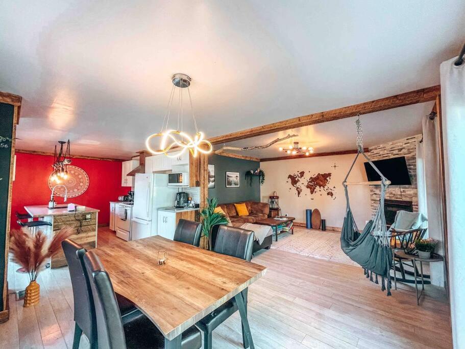 a living room with a dining table and a kitchen at Logement Mandala tout équipé in Saint Mathieu Du Parc