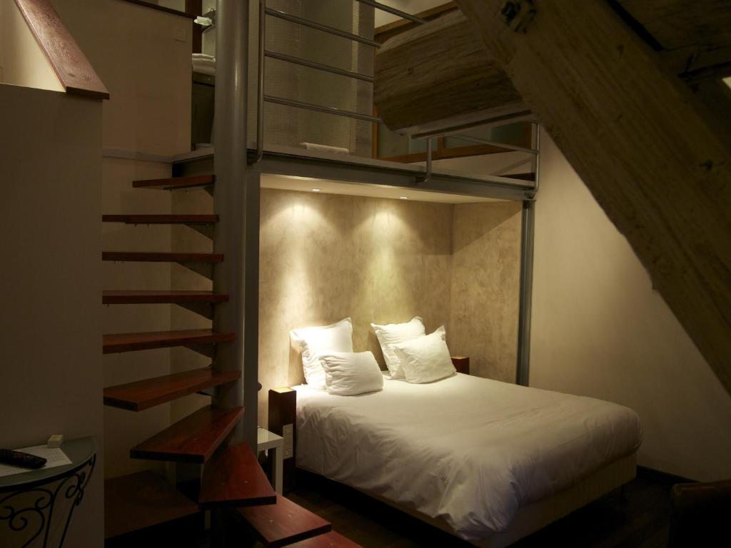 Ein Bett oder Betten in einem Zimmer der Unterkunft Logis Hôtel Les Pages