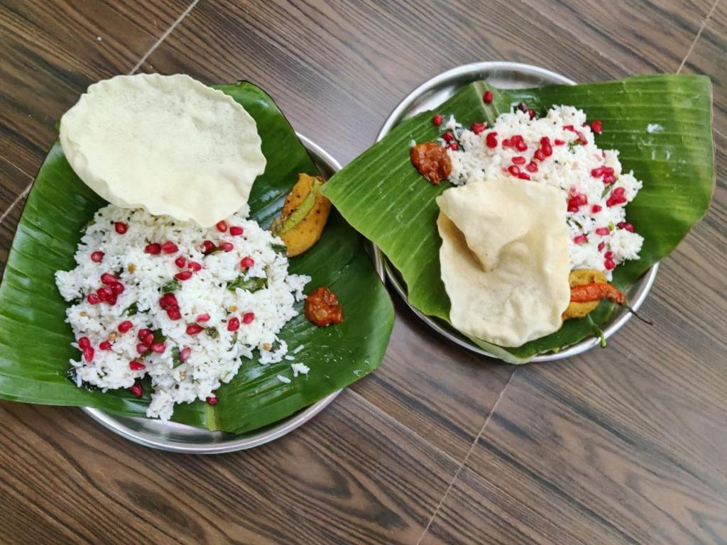 dos platos de comida encima de una hoja de plátano en Balaji Homestay en Hampi