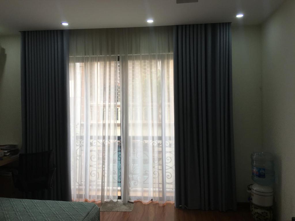 una camera da letto con una grande finestra con tende di Happy House 1 a Hanoi