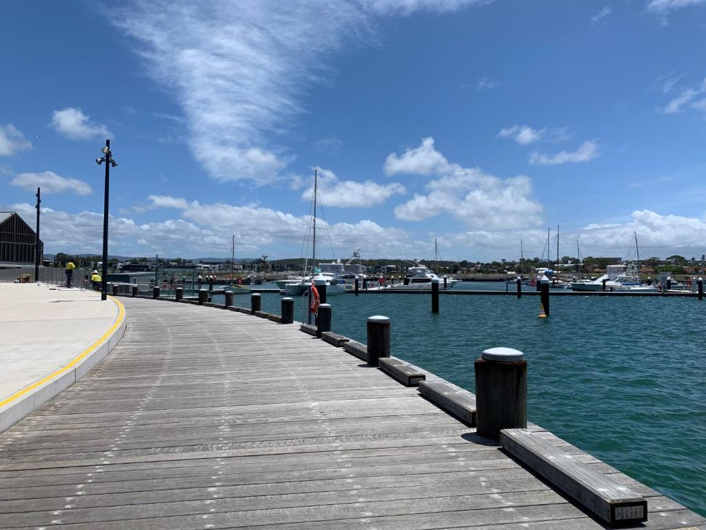 a dock with water and boats in a harbor at Pelicans Rest Shellharbour in Shellharbour