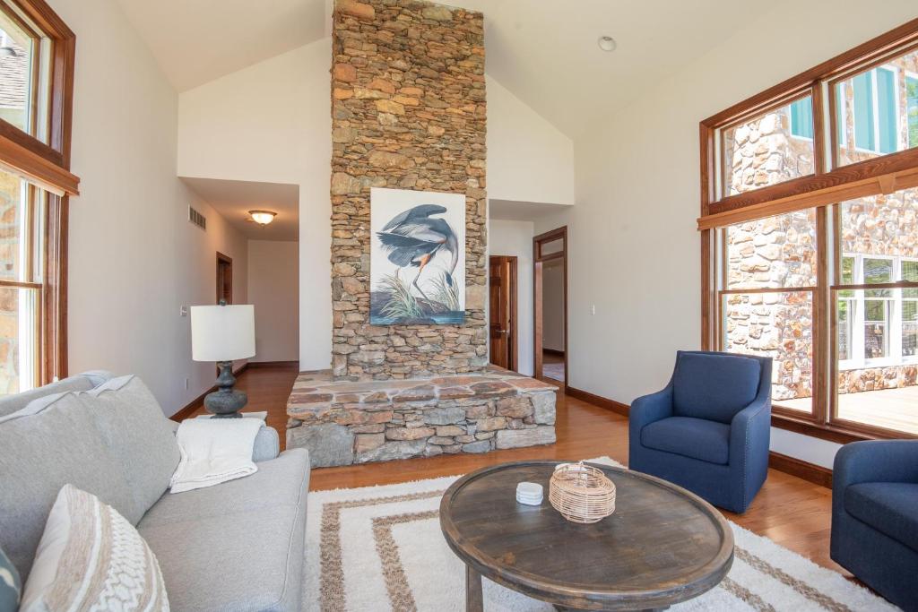 a living room with a couch and a stone fireplace at River Haven with Hot Tub in Delta