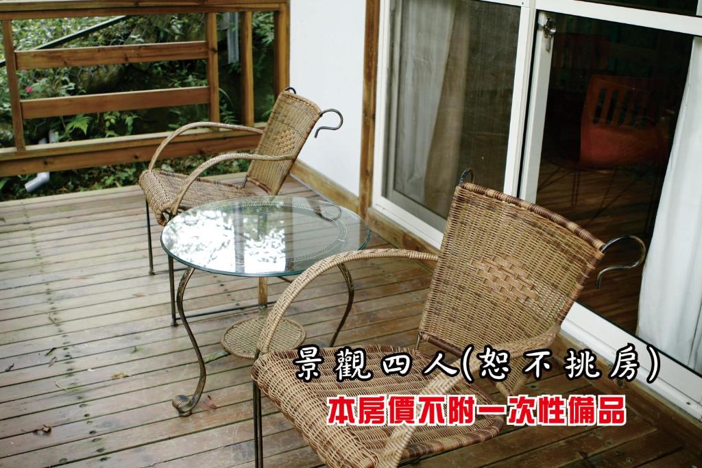 two chairs and a glass table on a porch at Tingtau Villa in Lugu Lake