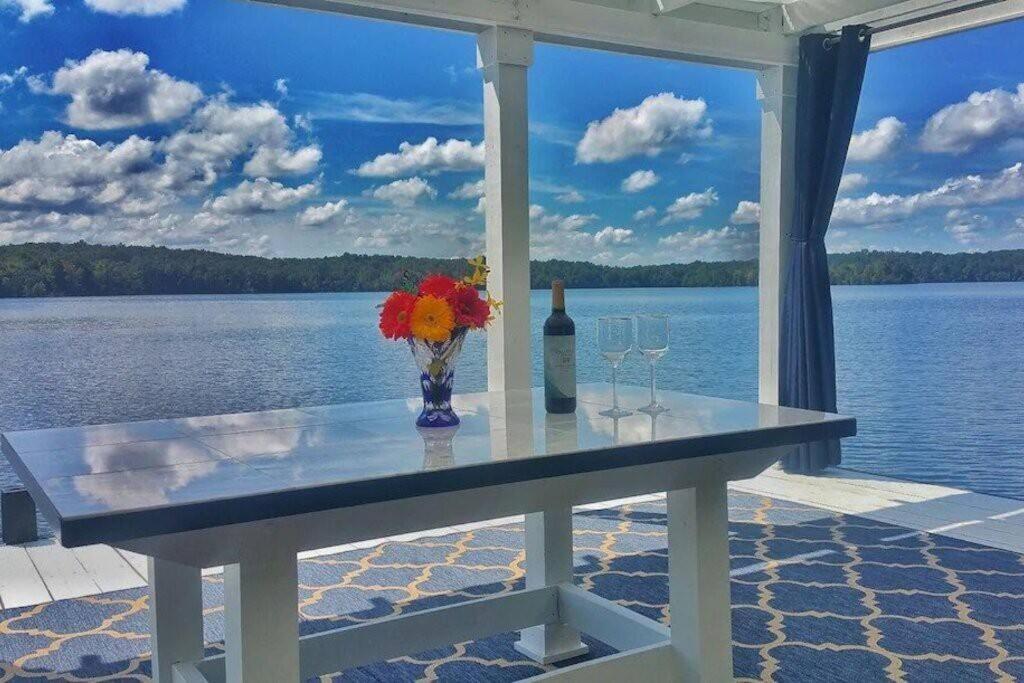 una mesa con un jarrón de flores y una botella de vino en Million Dollar Views: Lakefront, Dock, Kayaks+More, en Winchester