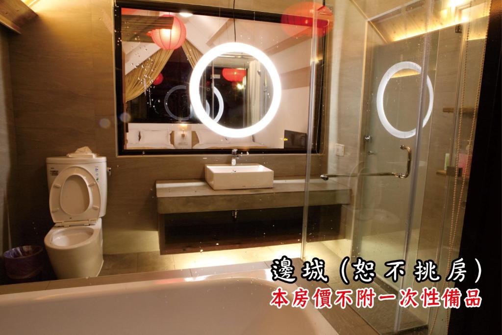 a bathroom with a sink and a toilet and a mirror at Tingtau Villa in Lugu Lake