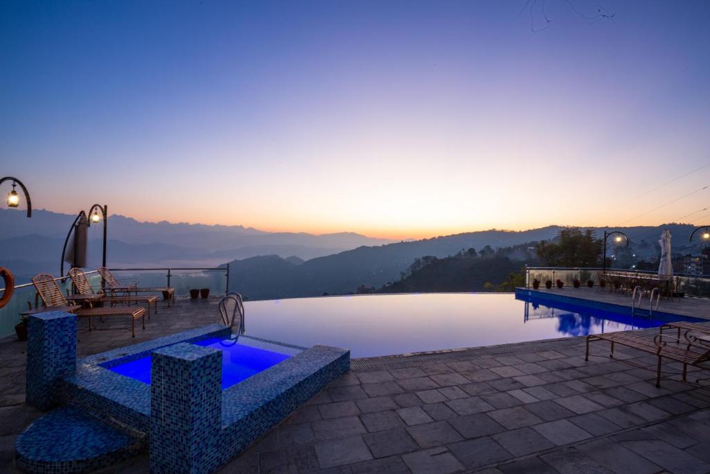 a resort with a pool with a view of the mountains at Himalaya Drishya Resort in Dhulikhel