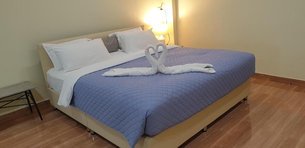 uma cama com dois cisnes feitos de toalhas em Na Cha Lae 1 ณ ชเล em Chanthaburi