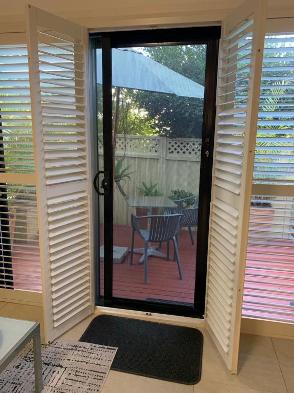 a room with a sliding glass door with a table at Pelicans Rest Shellharbour in Shellharbour