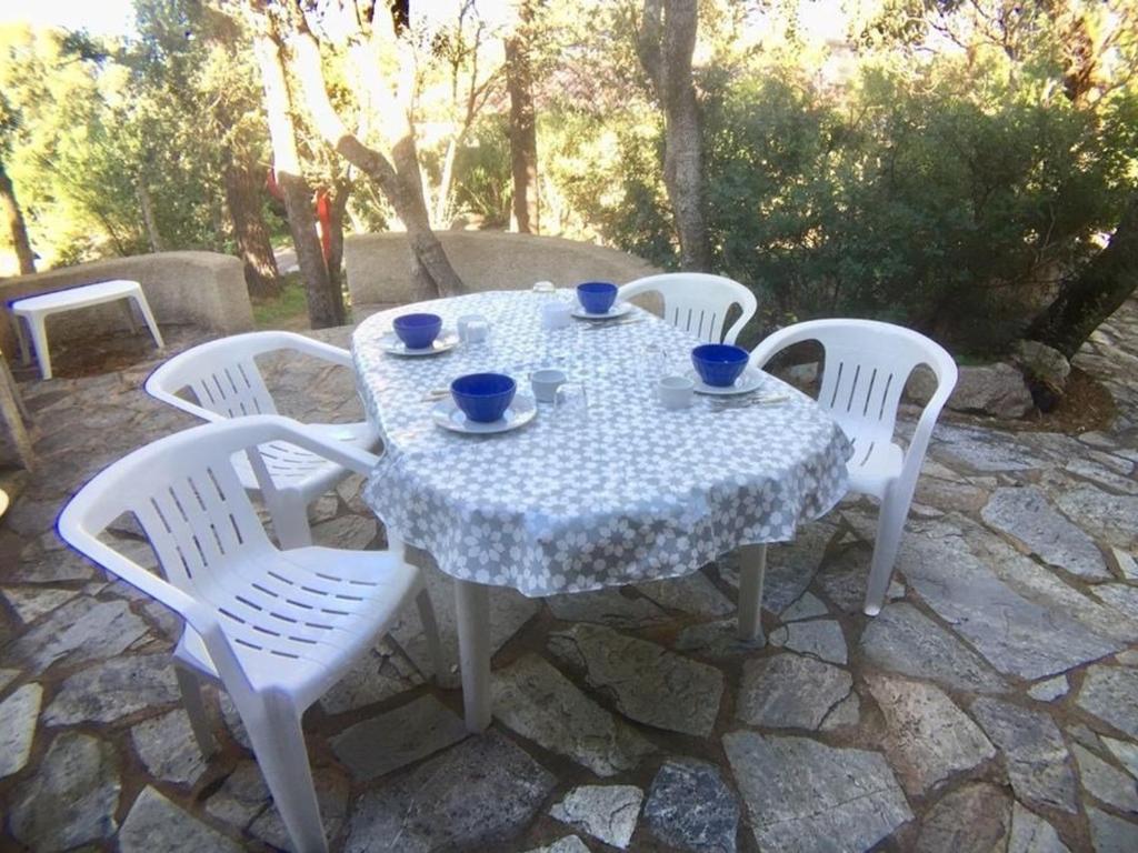 a table with four chairs and a white table and chairs at Maison Porto-Vecchio, 3 pièces, 6 personnes - FR-1-62-152 in Porto-Vecchio