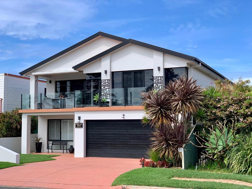 a large white house with a garage at Pelicans Rest Shellharbour in Shellharbour