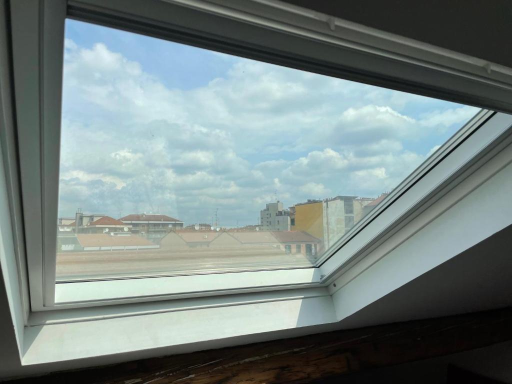 a window with a view of a city at Delizioso attico privato, comfort, cool. in Milan