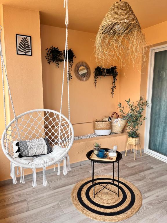 Zimmer mit einem Schaukelstuhl und einem Tisch in der Unterkunft Aquamarine apartment in Marina Sotogrande in Torreguadiaro