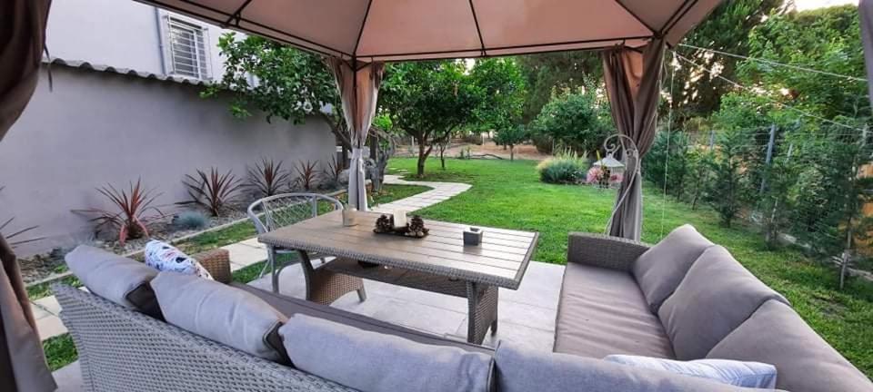 eine Terrasse mit einem Tisch, einem Sofa und einem Sonnenschirm in der Unterkunft Seaside house for 8 close to Olympia & the beach in Levendokhórion