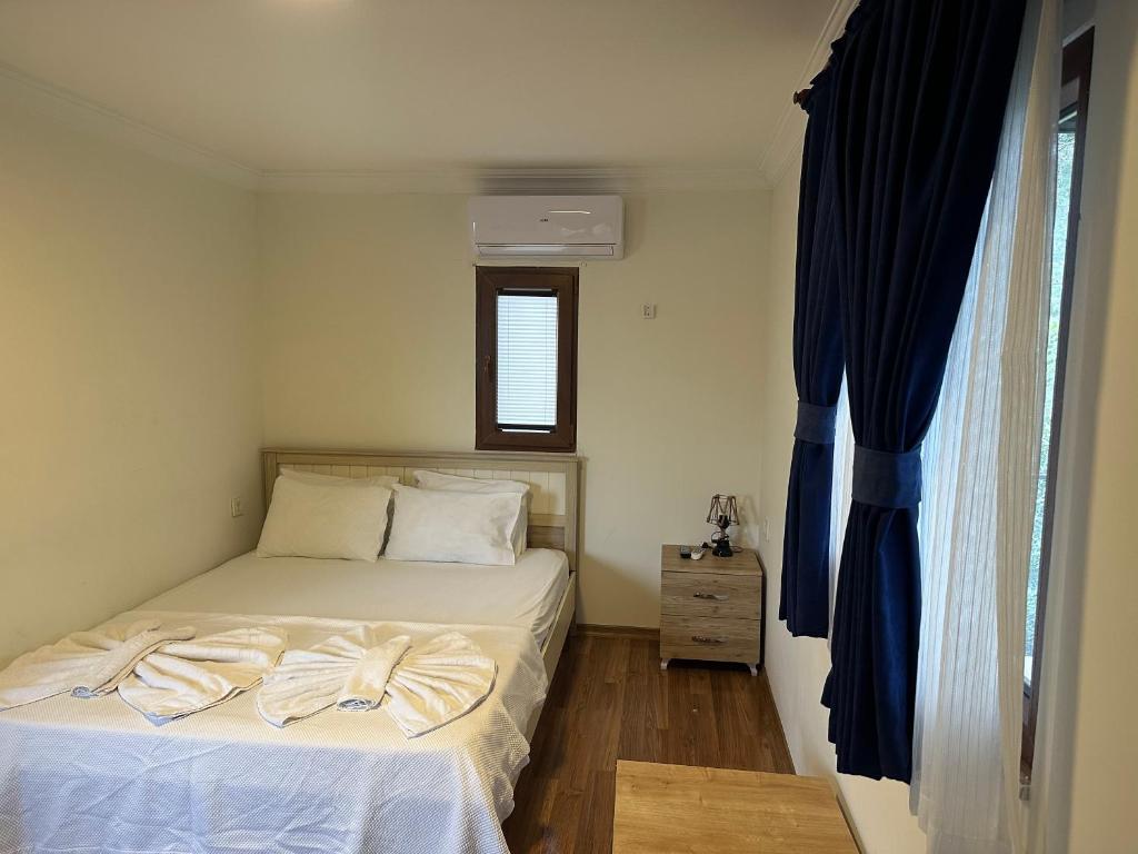 a small bedroom with a bed and a window at yenivadi in Antalya