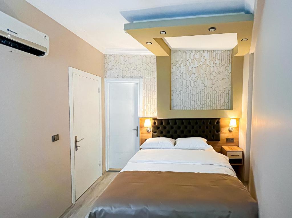 ein Schlafzimmer mit einem großen Bett in einem Zimmer in der Unterkunft Helen Inn in Izmir