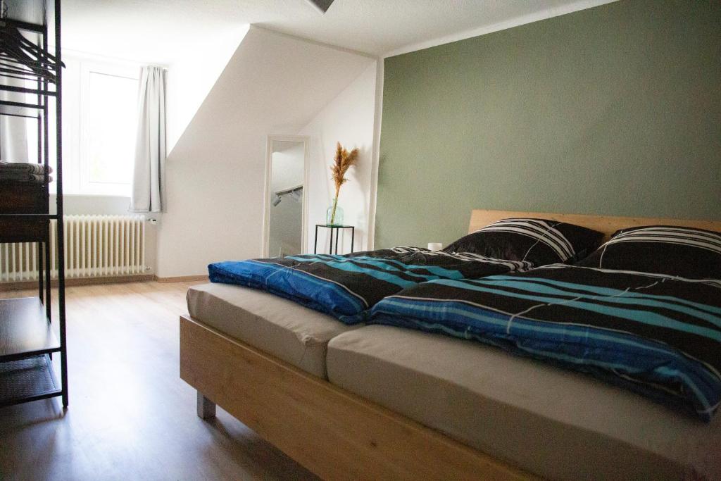 1 dormitorio con 1 cama grande y pared verde en Ferienwohnung mitten in Saarburg en Saarburg