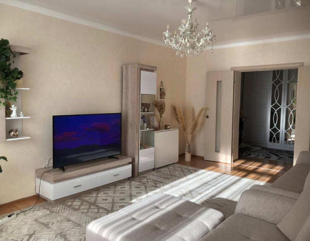 a living room with a television and a couch at at HOME in Prigorodnyy