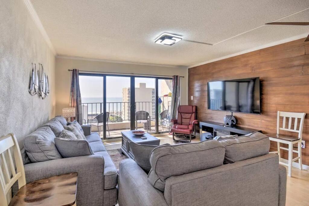 a living room with two couches and a television at Coastal Escape Penthouse with Ocean Views in Myrtle Beach