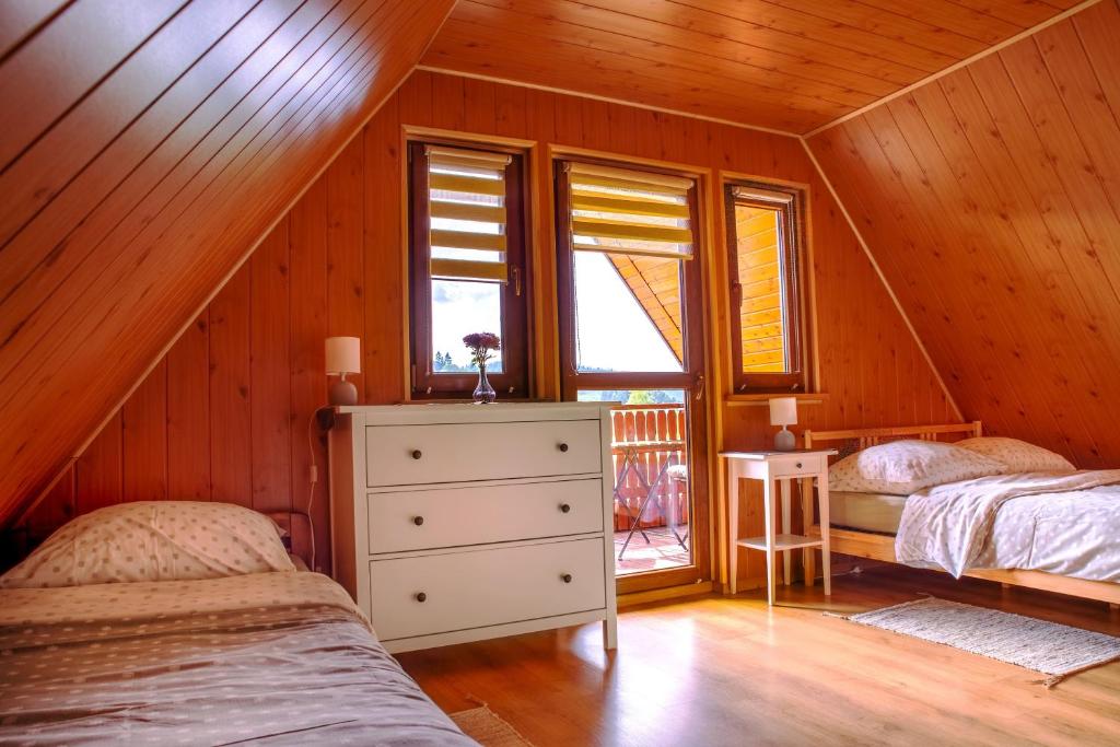 a bedroom with two beds in a wooden house at Czernyszówka in Bystre