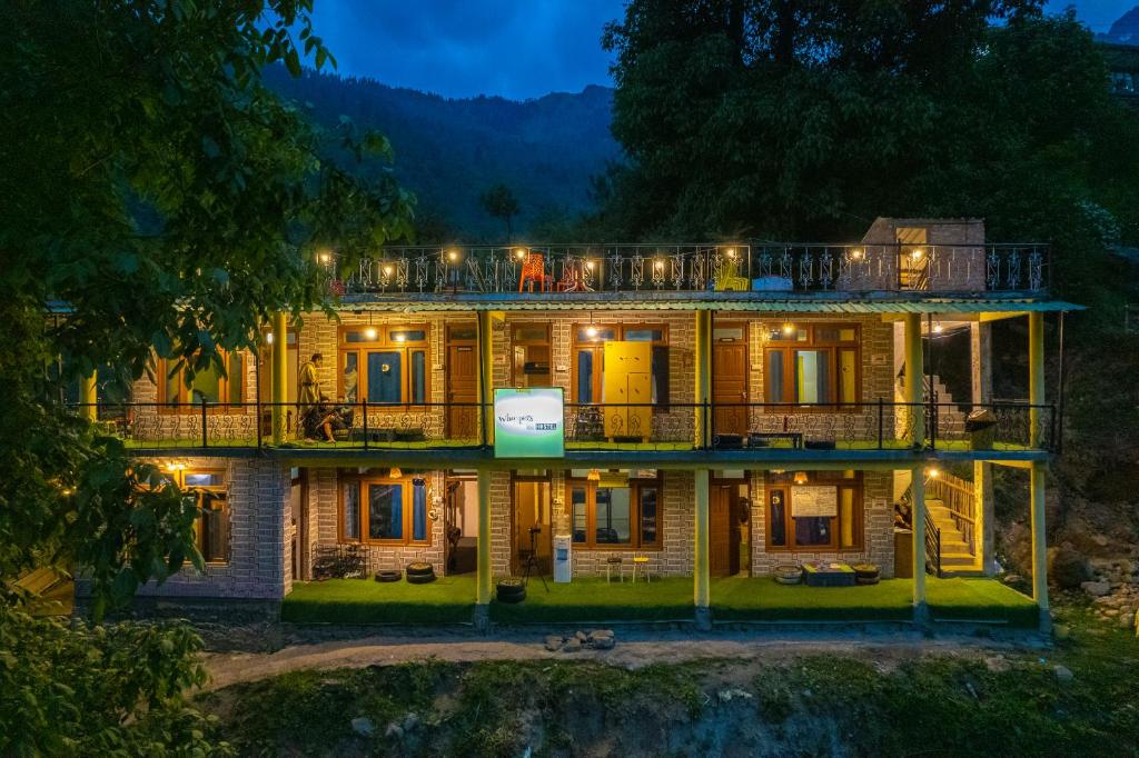 a large house with lights on it at night at Whoopers Hostel Tosh in Tosh