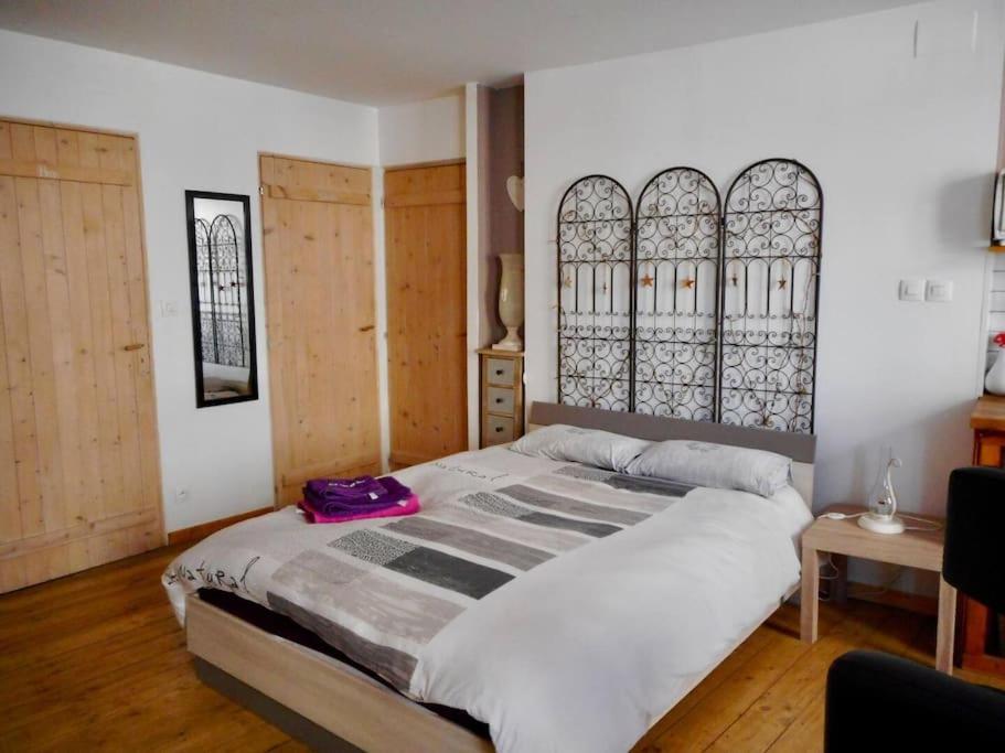 - une chambre dotée d'un grand lit avec un sac pourpre dans l'établissement Studio cosy au cœur de la nature, à Gorze