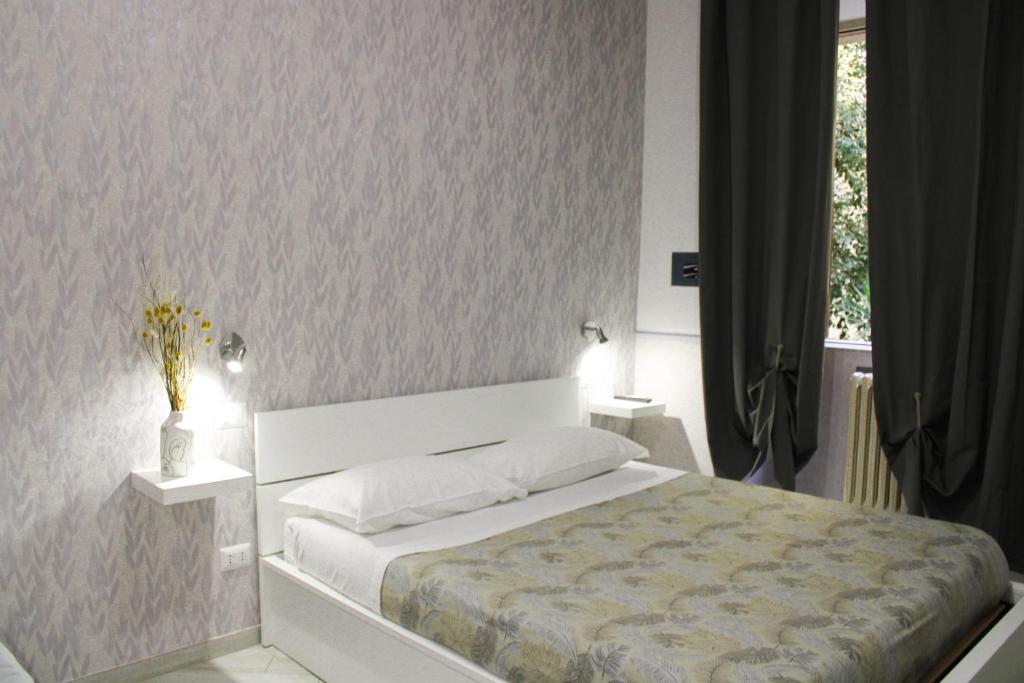 1 dormitorio con 1 cama con 2 mesitas de noche y una ventana en Eufonia Vatican Days, en Roma