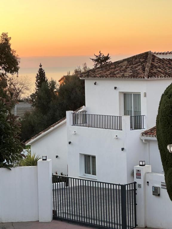 Biały dom z płotem przed nim w obiekcie Luxury Villa Andalucia Seaview Private Pool close to Centre w mieście Benalmádena