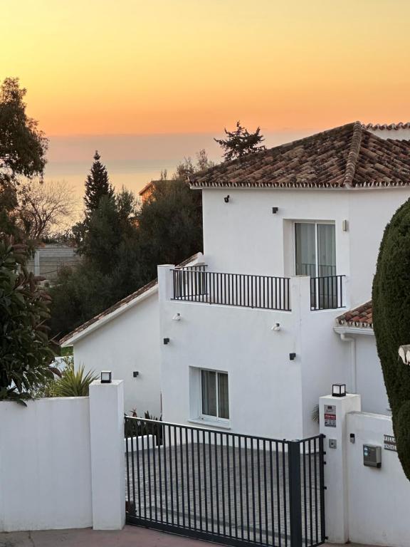 een wit huis met een hek ervoor bij Luxury Villa Andalucia Seaview Private Pool close to Centre in Benalmádena