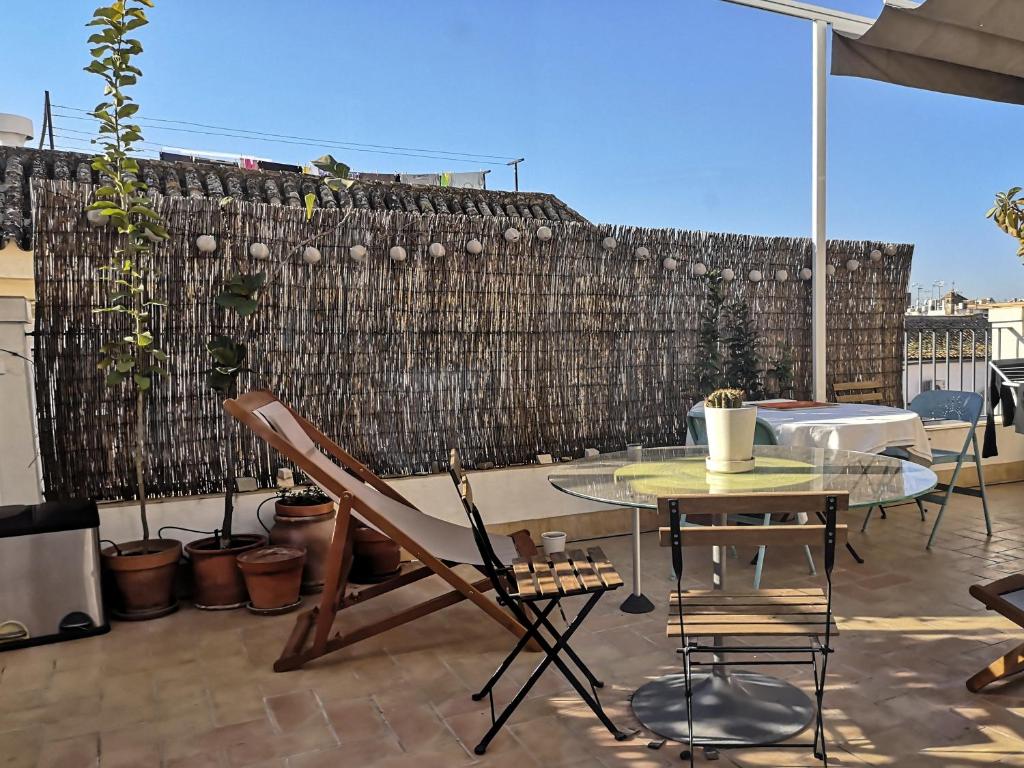 d'une terrasse avec une table en verre et une clôture. dans l'établissement White Room Alameda, à Séville