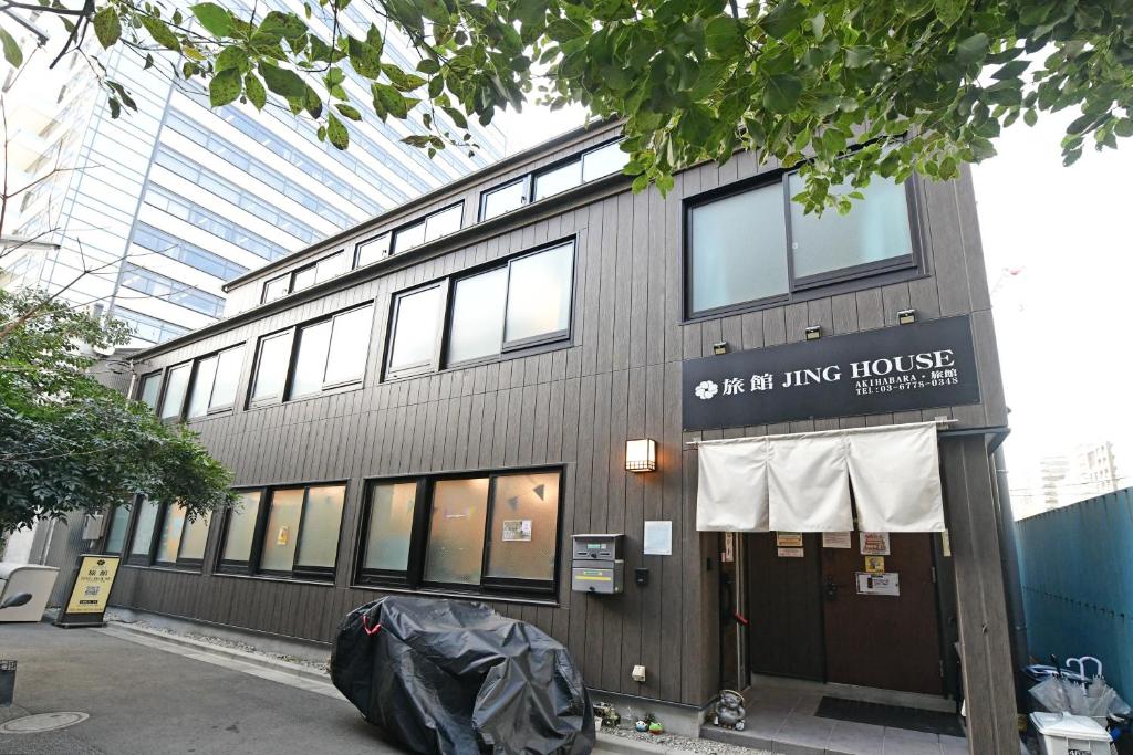 a building with a trash bag in front of it at 無料wi-fi JING HOUSE 秋葉原 電動自転車レンタル in Tokyo