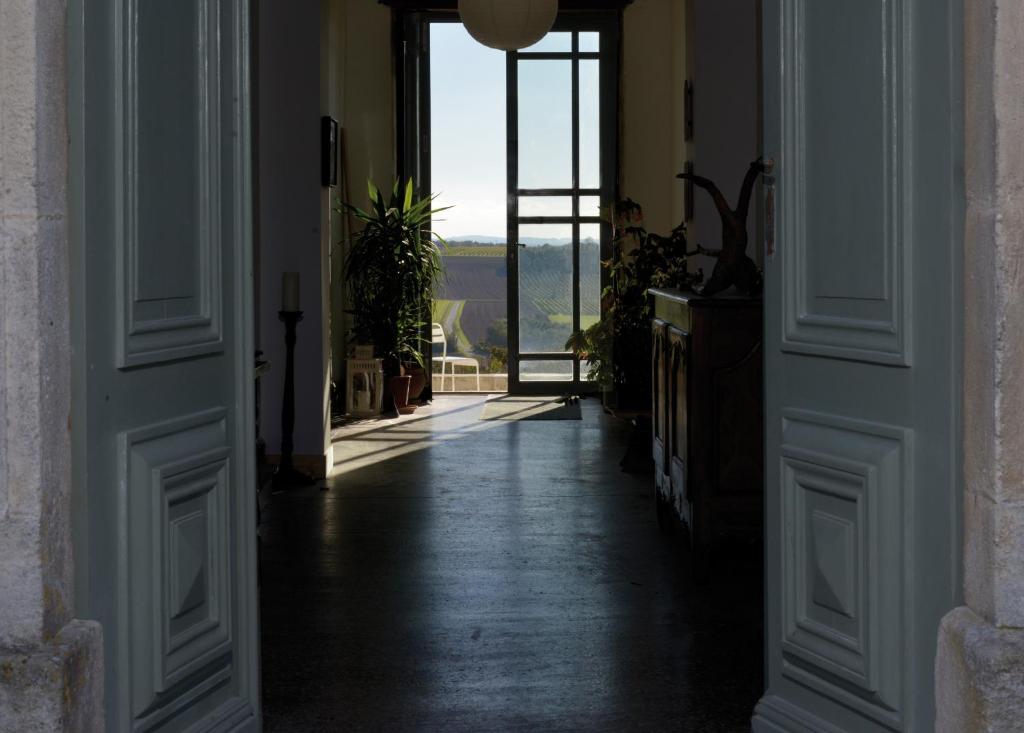 eine offene Tür mit Blick auf ein Zimmer mit Fenster in der Unterkunft Le Dojo du Plessis in Mareuil