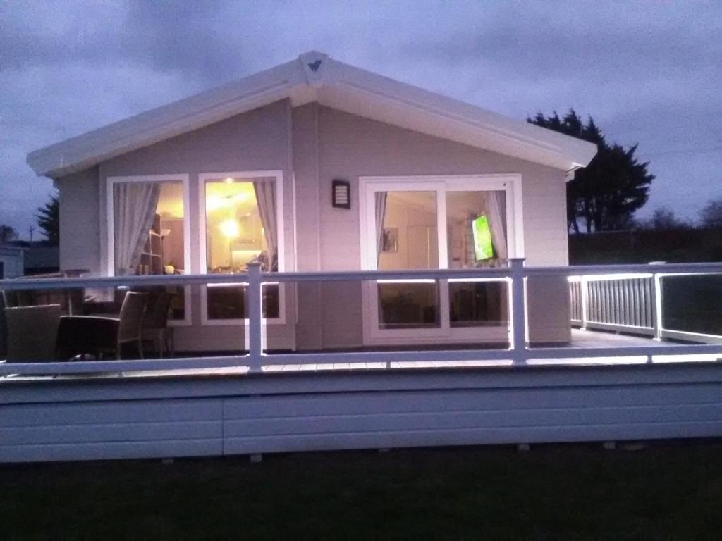 a small house with a large deck at night at Turnberry lodge in Girvan