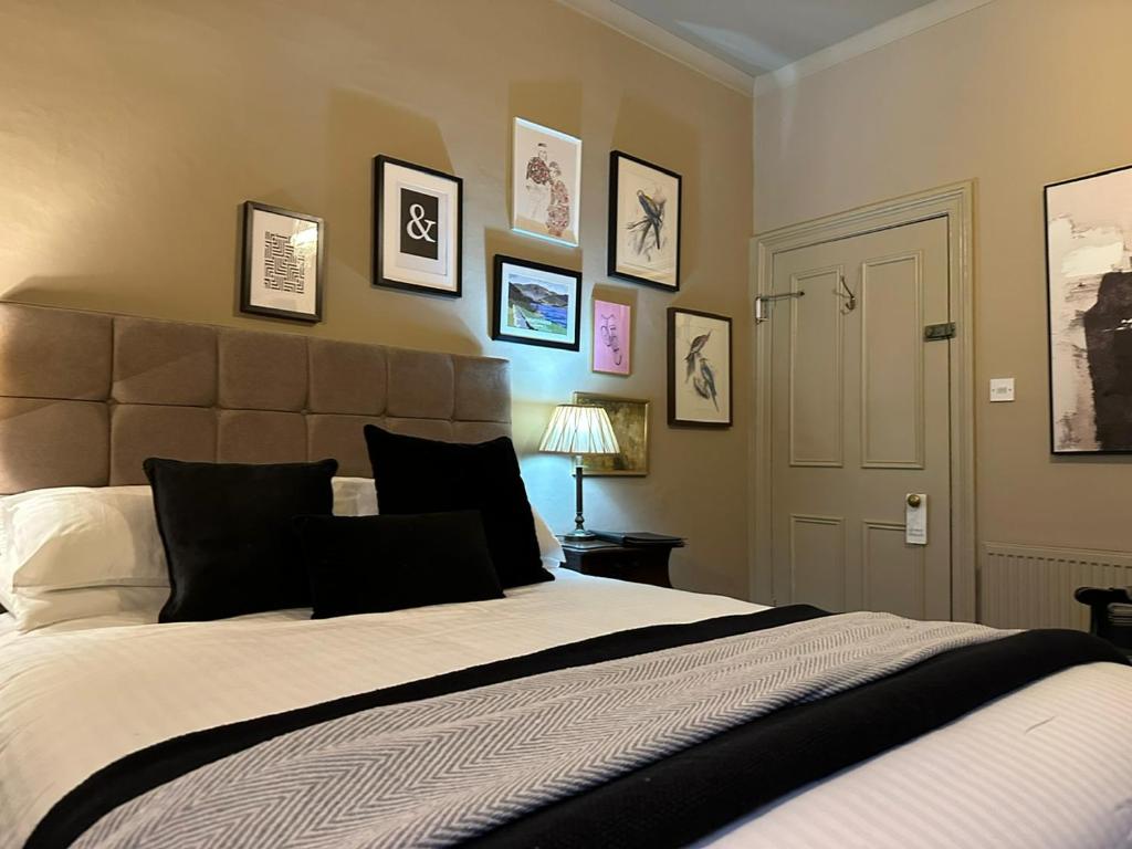 - une chambre avec un grand lit et des photos sur le mur dans l'établissement 1869 - Room Only Boutique Townhouse, à Ambleside