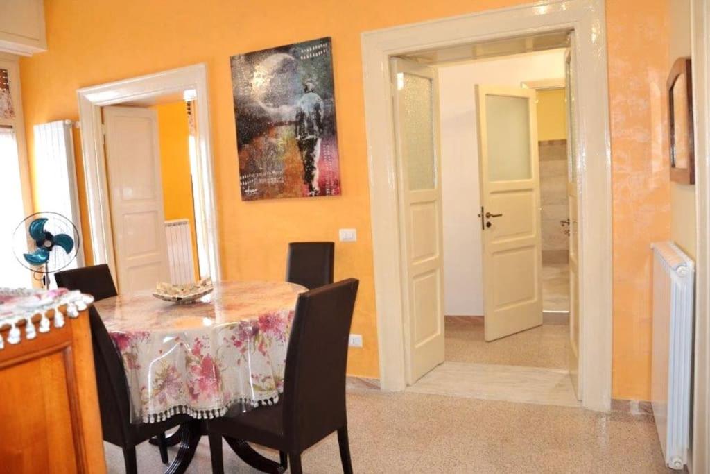 d'une salle à manger avec une table, des chaises et des murs orange. dans l'établissement Art Of Living - Esclusivo 130 MQ, à Isernia