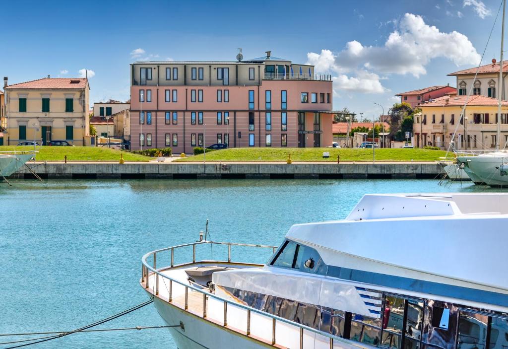 a boat docked in the water in front of buildings at L'incanto Di Boccadarno in Marina di Pisa