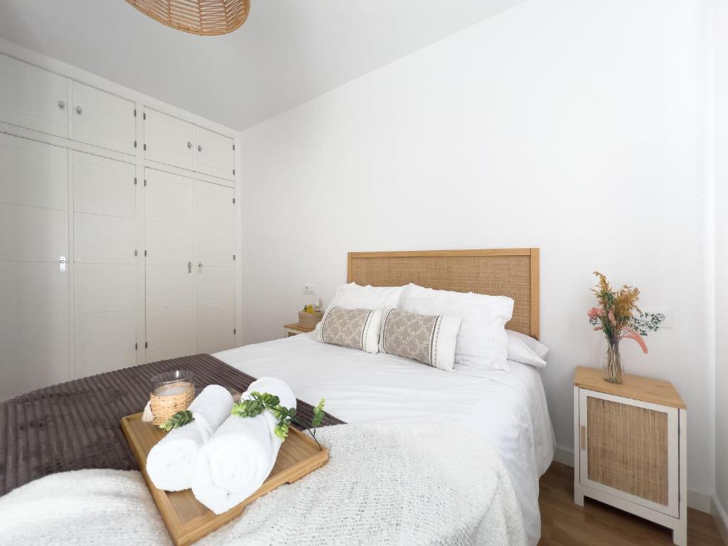 a bedroom with a bed with a tray with flowers on it at Apartamentos Turísticos Con Alma in Plasencia