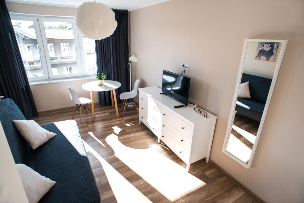 ein kleines Wohnzimmer mit einem TV und einem Spiegel in der Unterkunft Apartament Monte in Sopot