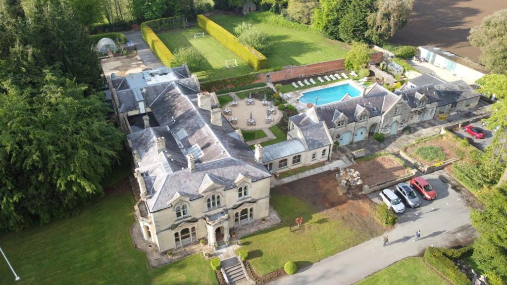 an aerial view of a large house with a pool at Beechfield House in Beanacre