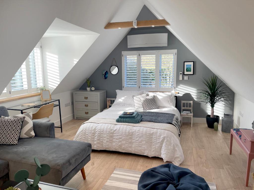 een slaapkamer met een groot bed en een stoel bij The Loft Hatch in Kent