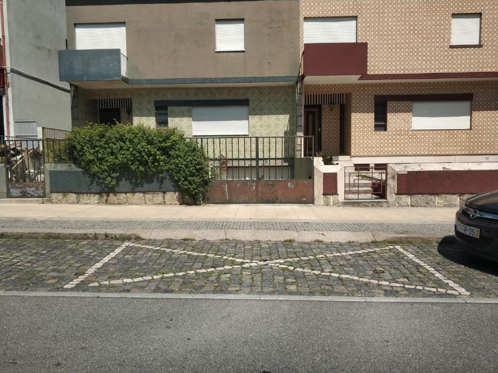 un estacionamiento frente a un edificio en Casa da Rosa, en Arcozelo